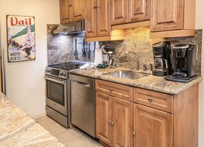 Enjoy cooking in this well-equipped kitchen with a stove, oven, dishwasher, double sink, and coffee maker.