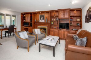 Cozy living room with a fireplace, comfortable seating area, and ample storage.