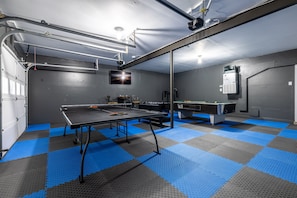 A room with a ping pong table, a pool table, and a ceiling-mounted projector. - 5 Bd home w/ GAME ROOM, Pet Friendly- Near I69/465 (Indianapolis)