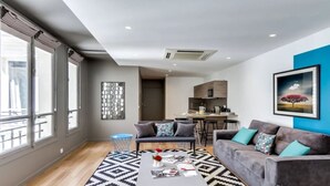 A modern apartment with a living room, kitchen, and dining area. - A Bit of Glamour and Magic in Champs Elysees (Paris)