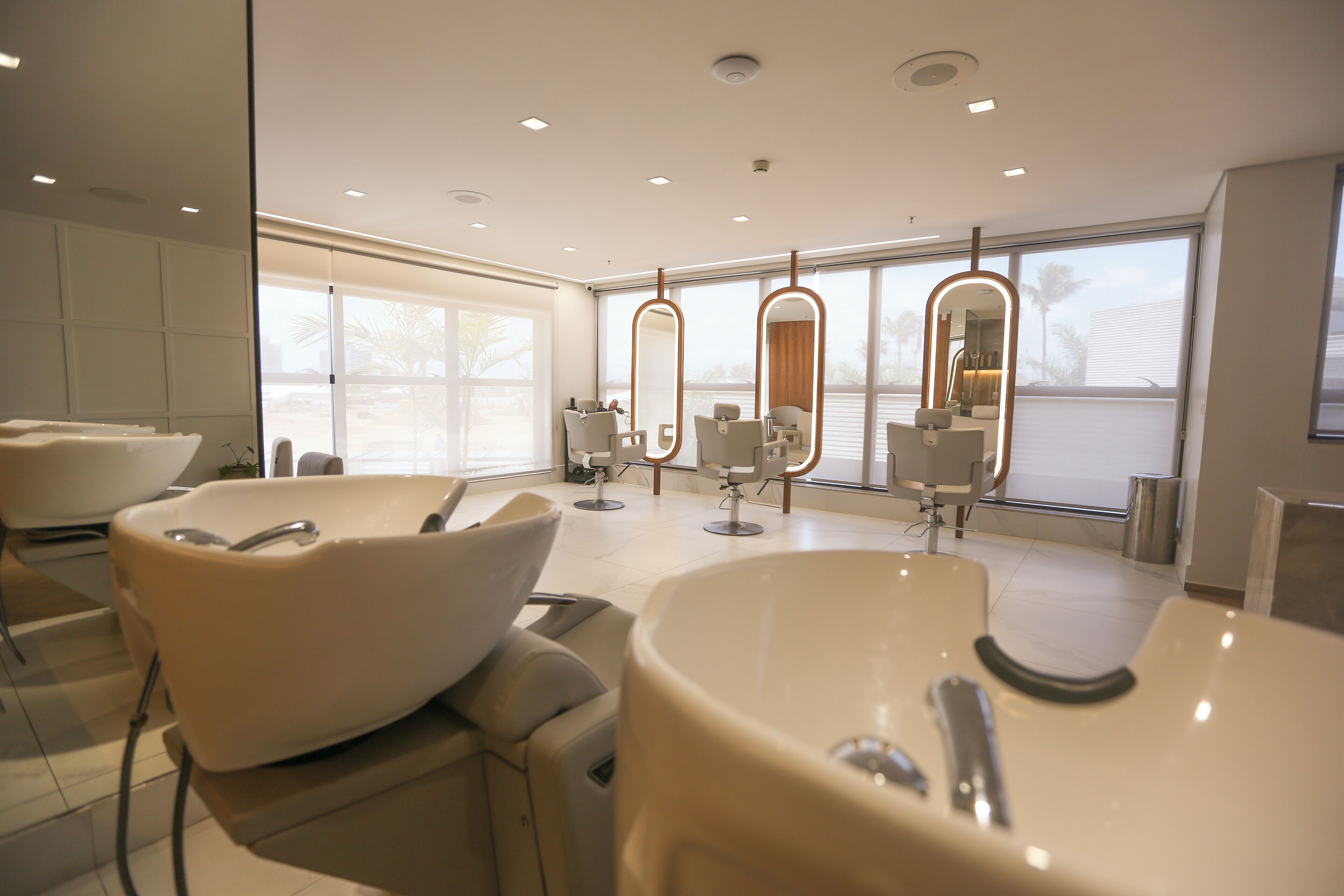 A modern bathroom with a large bathtub, a vanity with a mirror, and a large window providing natural light.