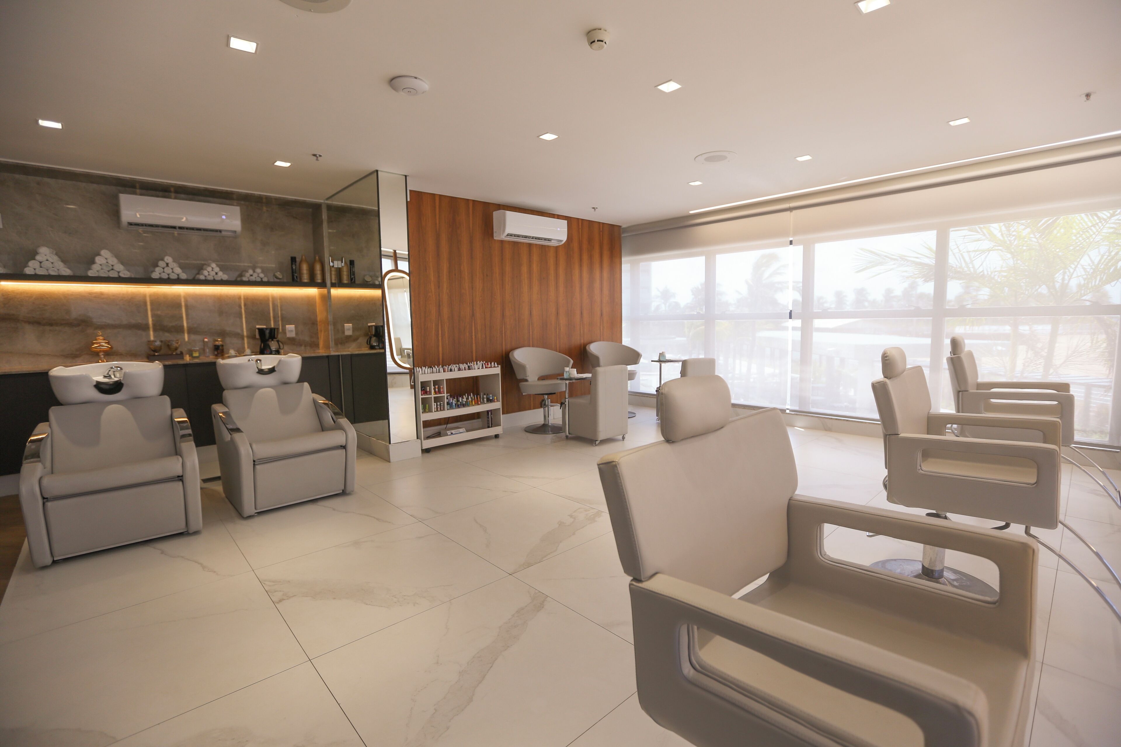 A modern waiting area with multiple seating options, a reception desk, and a large window providing natural light.