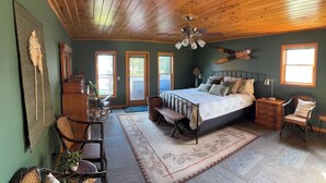 A bedroom with a bed, wooden ceiling, two windows, a desk, and a chair. - “The Lake house” Private BEACH; SLEEPS 16!!! (Schroon Lake)
