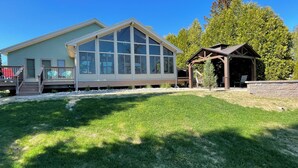 A two-story house with a large glass window and a covered porch. - “The Lake house” Private BEACH; SLEEPS 16!!! (Schroon Lake)