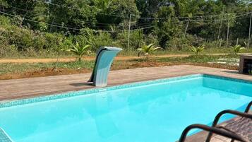 Alberca al aire libre, sombrillas en la alberca y camastros