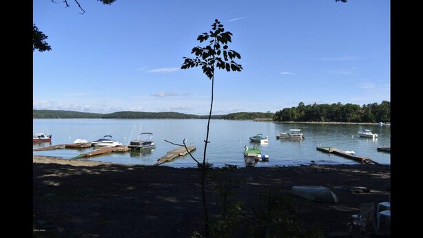 A lakeside dock with boats and a clear sky. - Cozy Lakeview Family Cottage - steps to the lake, 2 swim docks & restaurant! (Hawley)