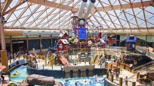 Ein großer Indoor-Wasserpark mit mehreren Pools, Wasserrutschen und Spielbereichen.