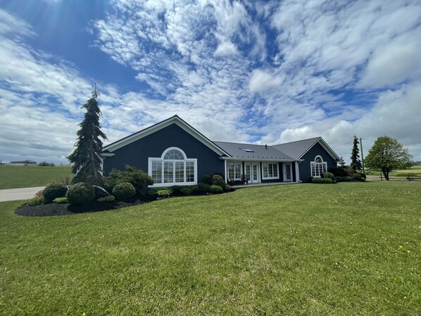 A two-story house with a large front porch, a covered entryway, and a well-maintained lawn.