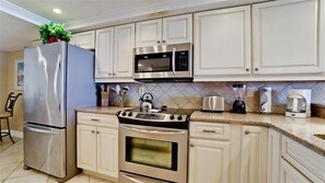 Enjoy cooking in this well-equipped kitchen with a stainless steel refrigerator, microwave, oven, and toaster.