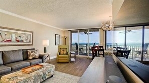Relax in this ocean-view living area with a sofa, coffee table, dining table, and chairs.