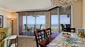 Enjoy ocean views from the comfort of this room, featuring a dining table, sofa, and ceiling fan.