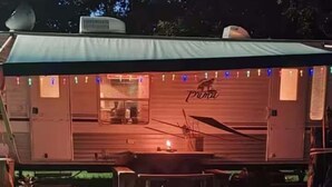 Uma autocaravana coberta com o logótipo 'Puma', uma área de cozinha e uma mesa de jantar.
