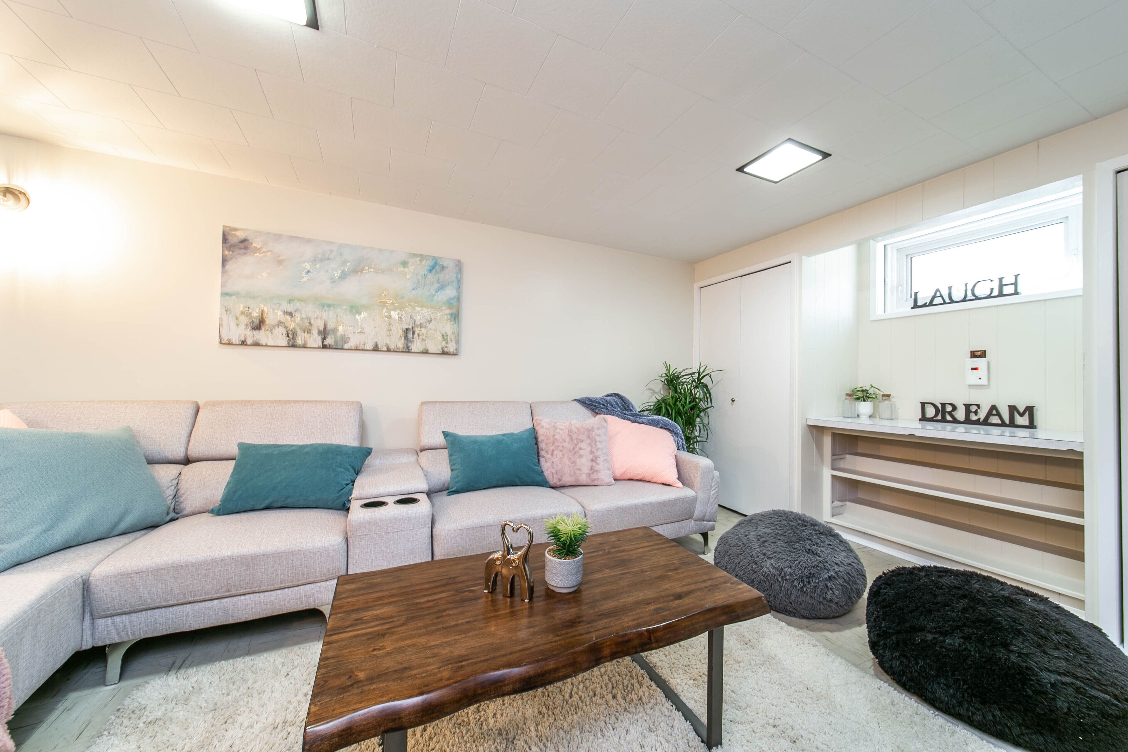 A modern living room with a sofa, coffee table, and a wall-mounted shelf with decorative items.