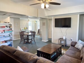 Relax in this spacious living room with a sofa, coffee table, and mounted TV.