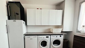 A compact laundry area with a washing machine, dryer, and a small refrigerator. - ☀︎ Quiet house - 5min from Cognac - 1/8 pers ☀︎ (Cherves-Richemont)