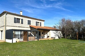 A two-story house with a covered patio and a fenced garden. - ☀︎ Quiet house—5 minutes from Cognac—sleeps 1–8 ☀︎ (Cherves-Richemont)