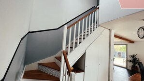 A staircase with wooden steps and white railings leading to a room with a sliding door. - ☀︎ Quiet house - 5min from Cognac - 1/8 pers ☀︎ (Cherves-Richemont)