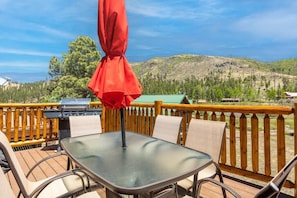 Enjoy a mountain view from this outdoor deck with a barbecue grill and comfortable seating.
