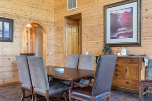 Enjoy meals in this cozy cabin-style dining area with a wooden table and comfortable chairs.