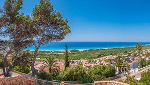 A coastal town with buildings, a beach, and a clear blue sky.