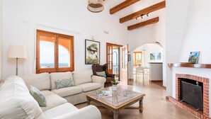A spacious living room with a sofa, coffee table, and fireplace.