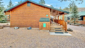 A log cabin with a covered porch and a gravel driveway. - Monteverde Getaway (Cabin 106) (Greer)