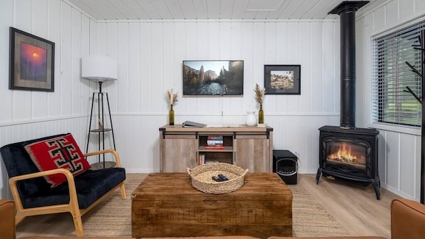 A cozy living room with a sofa, a coffee table, a fireplace, and a television. - Aspen Cabin 2 (Greer)