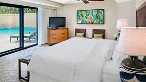 Une chambre d’hôtel avec un grand lit, une télévision, un tableau et une vue sur une piscine.
