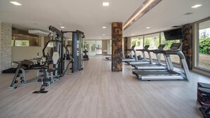 A gym with treadmills, weight machines, and a brick wall. - GOLDEN GRAMADO RESORT LAGHETTO (Gramado)