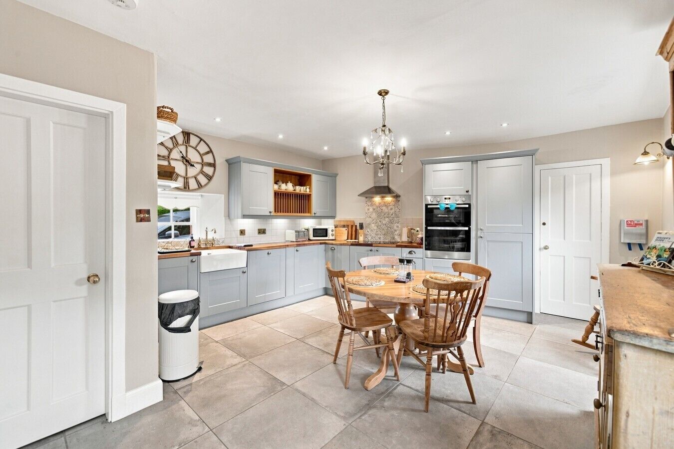 A modern kitchen with a dining table, chairs, and built-in appliances.