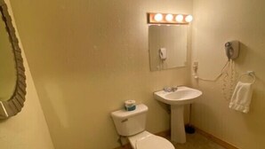 Un baño pequeño con inodoro, lavamanos y espejo.
