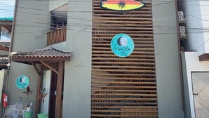 A two-story building with a modern design, featuring a balcony on the upper floor and a small entrance with a tiled roof. - Clara Lua Suites (Ipojuca)