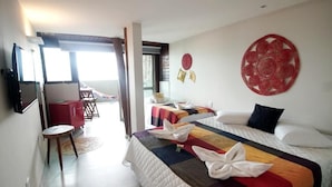 A hotel room with two beds, a TV mounted on the wall, and a view of the outside balcony. - Clara Lua Suites (Ipojuca)