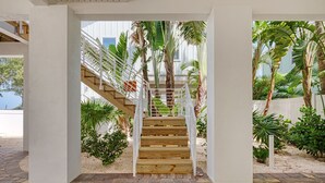 A wooden staircase with white railings leading to a covered area with plants. - AMI Gulf Lookout-views Of The Gulf From Every Room-rooftop Terrace (Bradenton Beach)