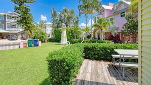 Un quartier résidentiel avec une pelouse bien entretenue, une terrasse en bois et un kiosque.