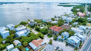 Vue aérienne d’une zone résidentielle côtière, avec des maisons, une marina et une vaste étendue d’eau.