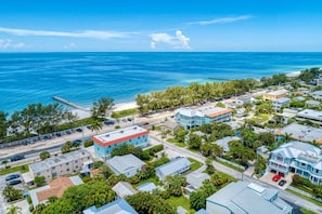 An aerial view of a coastal residential area with houses, a pier, and a beach. - AMI Lighthouse Cottage-one Minute Walk To The Beach-keyless Locks (Bradenton Beach)