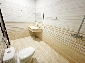 A bathroom with a toilet, sink, and mirror.
