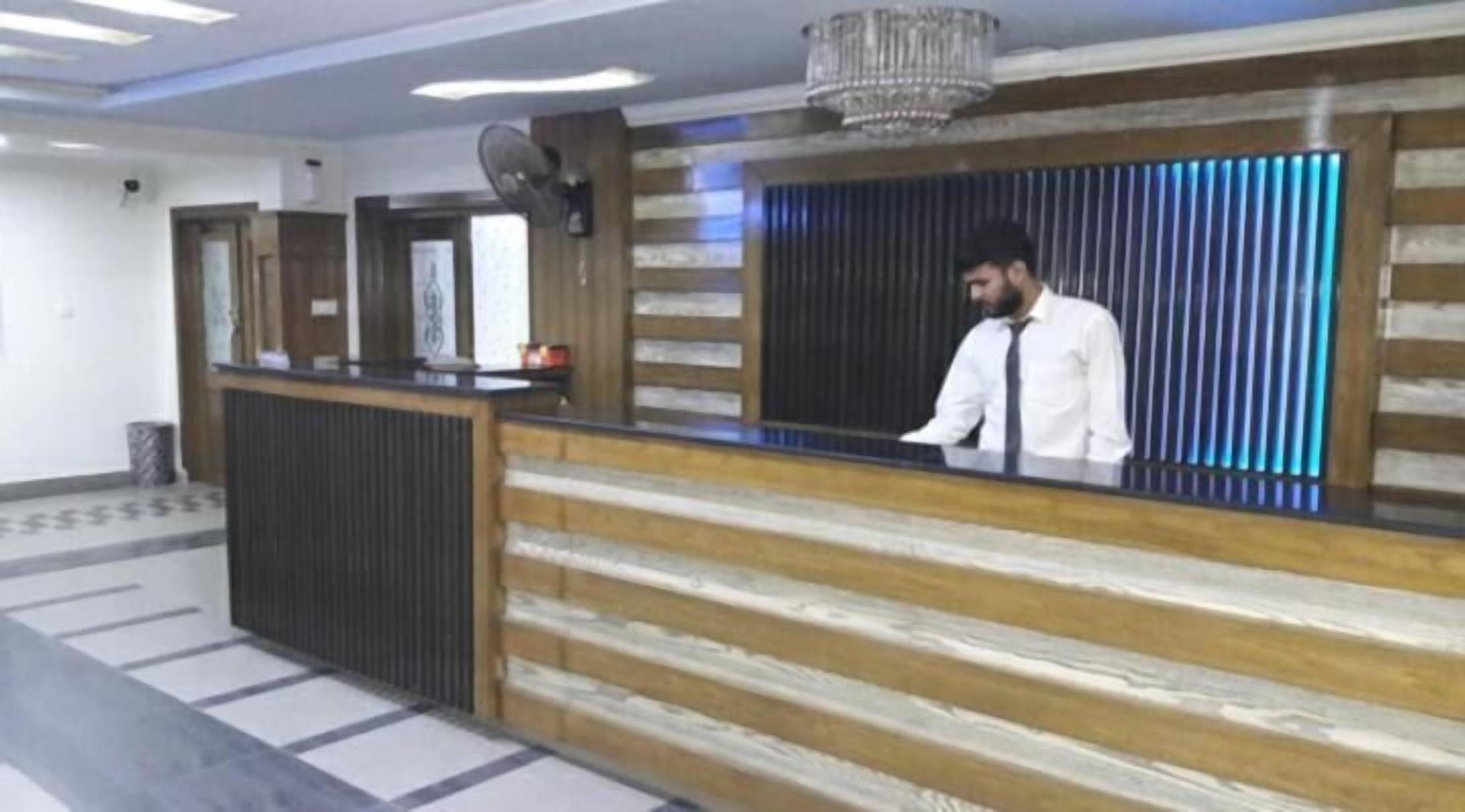 A reception desk with a wooden finish and a modern chandelier.