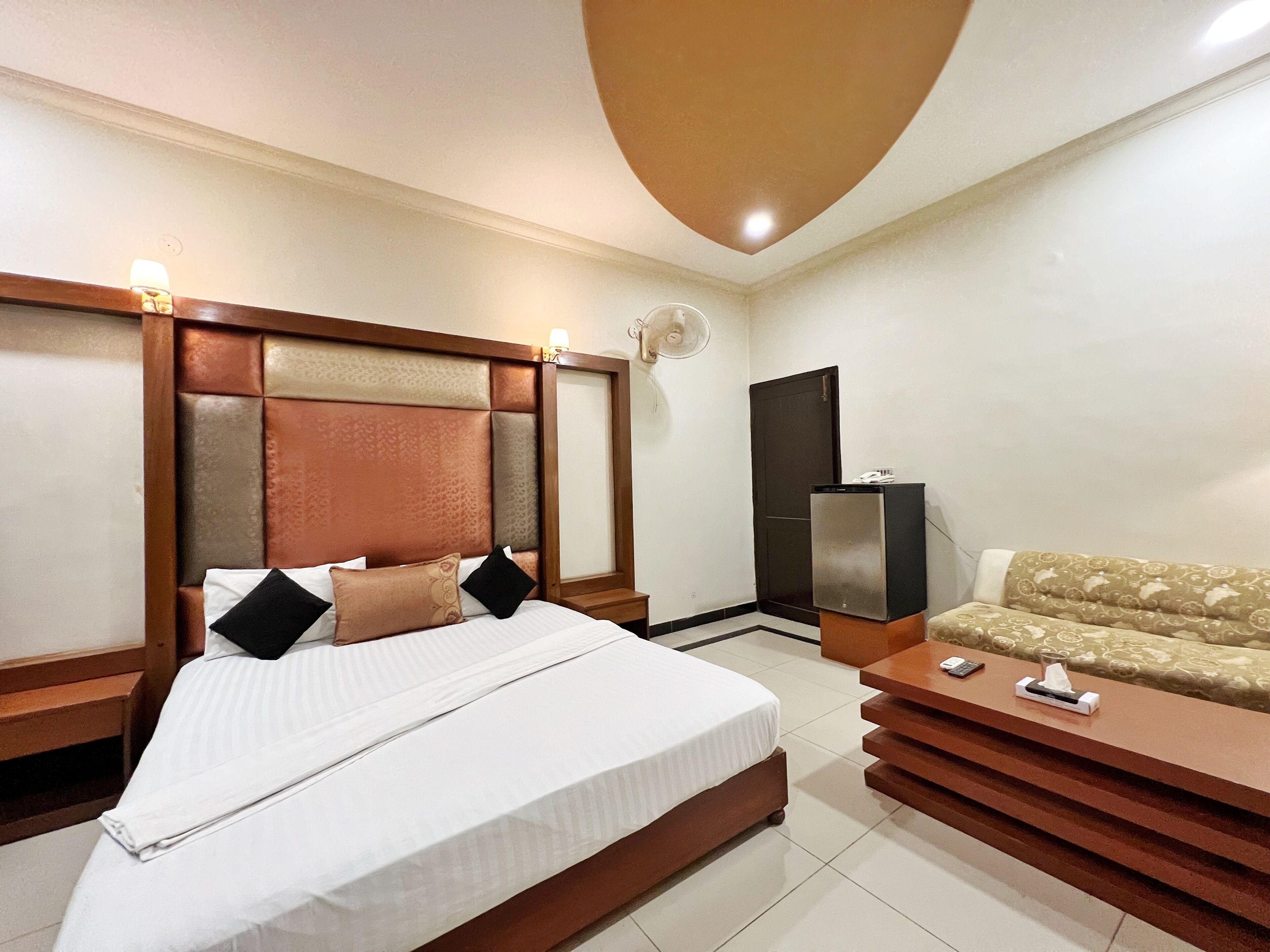 Habitación de hotel con una cama grande, un sofá, un escritorio y un mini bar.