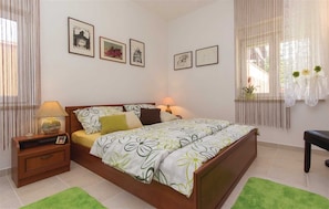 A neatly arranged bedroom with a bed, bedside tables, and framed pictures on the wall.