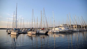 Eine Marina mit mehreren Segelbooten, die in ruhigem Wasser vor Anker liegen.