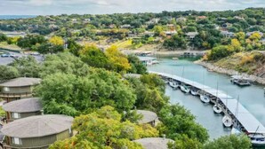 Une vue sur le fleuve, avec des bateaux amarrés, un pont et des immeubles d’habitation.