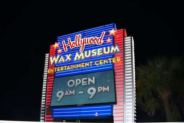 Letrero del Museo de Cera de Hollywood que muestra 'ABIERTO 9AM - 9PM'.