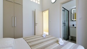 Ein Hotelzimmer mit Bett, Schrank, Badezimmer mit Spiegel und Fenster.