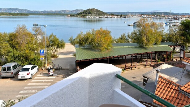 A marina with boats, a covered seating area, and a parking sign.