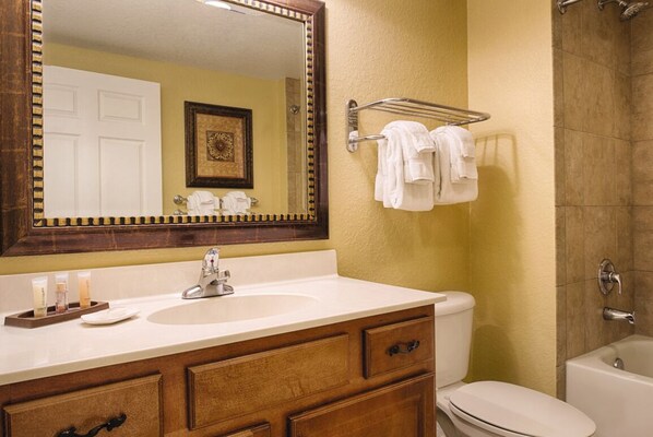 Une salle de bain équipée d’un lavabo, d’un miroir, d’un porte-serviettes, de toilettes et d’une baignoire.