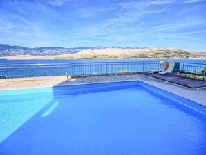 Une piscine avec vue sur la mer et les montagnes.