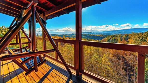 A wooden deck with a swing, overlooking a forested valley with mountains in the distance. - 🏔🏔 180° Views 🏔🏔 ❸Decks ❸Masters ❷Game R♨Hot T (Sevierville)