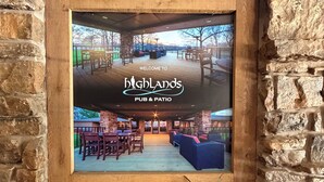 A framed interior view of Highlands Pub & Patio with stone walls and wooden flooring.